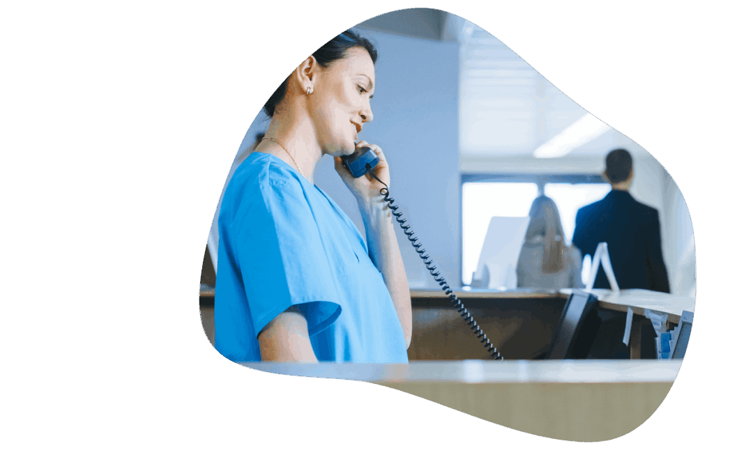 Woman using voip phone in hospital front desk